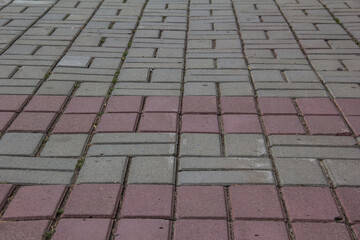 Fototapeta premium the sidewalk is paved with pink and gray tiles.
