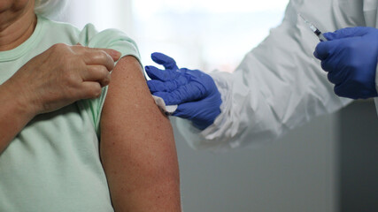 Doctor holding syringe and using cotton before make injection to patient. Vaccination and prevention against flu or virus pandemic.