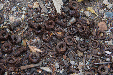 Rusty bolts and nuts lying on the ground.