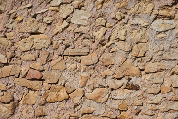 Wall made of brown stones. Stone textured wallpaper