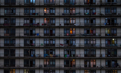windows and balconies of a residential building in a slum, in the evening, dusk, urban background