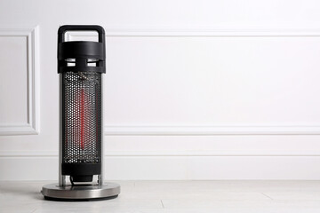 New modern electric heater on floor in room, space for text