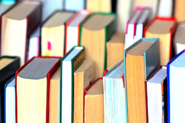 This is a lot of books standing together in several rows. Solid background of books in close-up....