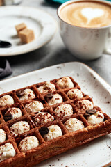 large waffles with filling on a gray background with coffee