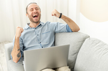 Happy young man received good news on the email, got promoted, won in game, a overjoyed hipster guy...
