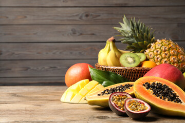 Fresh ripe papaya and other fruits on wooden table. Space for text