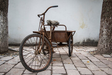 Fototapeta na wymiar Rusty Bicycle On Footpath Against Wall