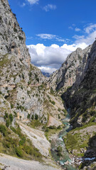 Fototapeta na wymiar The Cares Route in the heart of Picos de Europa National Park, Cain-Poncebos, Asturias, Spain. Narrow and impressive canyon between cliffs, bridges, caves, footpaths and rocky mountains.
