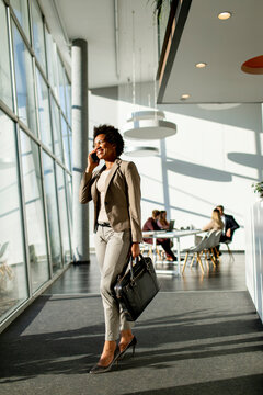 African American Business Woman Using Mobile Phone And Walking In The Office