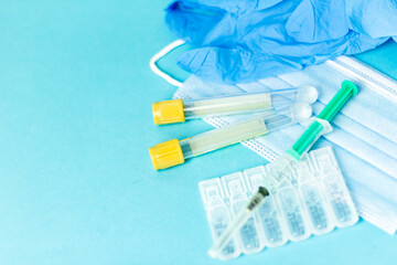 Medical vials for injection, syringe for injection, mask gloves on a blue background. Admission vaccination, flu shot.
