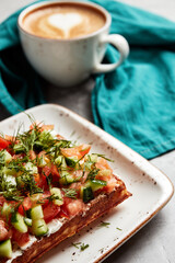 large waffles with filling on a gray background with coffee