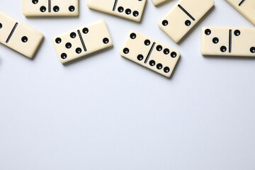 Classic domino tiles on white background, flat lay. Space for text