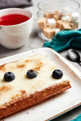 large waffles with filling on a gray background with coffee