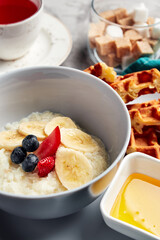 milk porridge with filling on a gray background with fruit tea