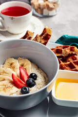 milk porridge with filling on a gray background with fruit tea