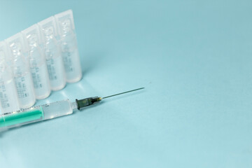 Medical vials for injection, syringe for injection, mask gloves on a blue background. Admission vaccination, flu shot.