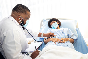 African American doctor wear a surgical masks Are using a stethoscope Listen and check for symptoms...