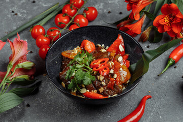 Beef wok. Traditional chinese mongolian beef stir fry in chinese cast iron wok with cooking chopsticks, stone slate background. Top view, copy space