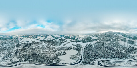 360 degree panorama of snow-capped mountains and winding road. Mountain serpentine road through a snowy forest. © Mahey
