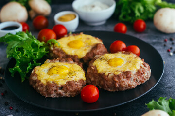 Beefsteak with egg on a plate. Delicious hot dish. The dish is decorated with cherry tomatoes and herbs. Beefsteak on a plate 