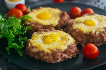 Beefsteak with egg on a plate. Delicious hot dish. The dish is decorated with cherry tomatoes and herbs. Beefsteak on a plate 