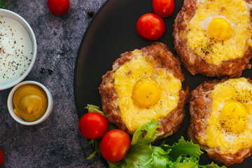 Beefsteak with egg on a plate. Delicious hot dish. The dish is decorated with cherry tomatoes and herbs. Beefsteak on a plate 