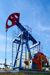 The blue and red oil rig on a sunny day against a blue sky. View from below.