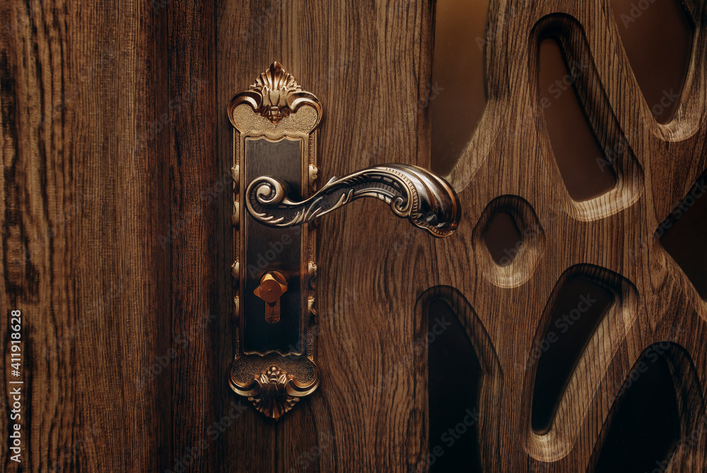 Wall mural vintage door handle. the handle that opens the door. vintage bronze door handle. dark wooden door wi