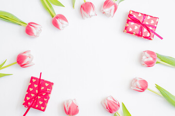 Flat lay valentines day frame with pink tulips and gift box on a white background