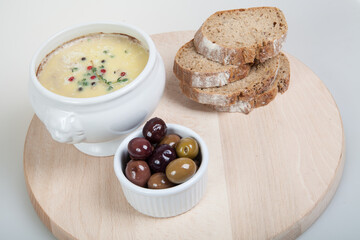 Homemade pate, olives and slices of bread on wooden board