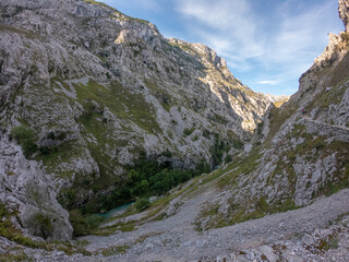 The Cares river canyon along the Cares Route in the heart of Picos de Europa National Park, Spain. Narrow and impressive canyon between cliffs, bridges, caves, footpaths and rocky mountains