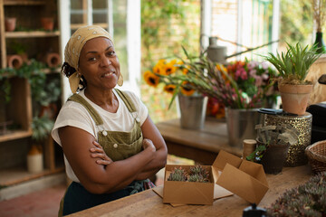 Portrait confident female florist boxing succulents in shop