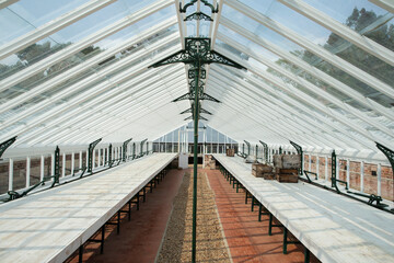 Tables in empty sunny garden center greenhouse
