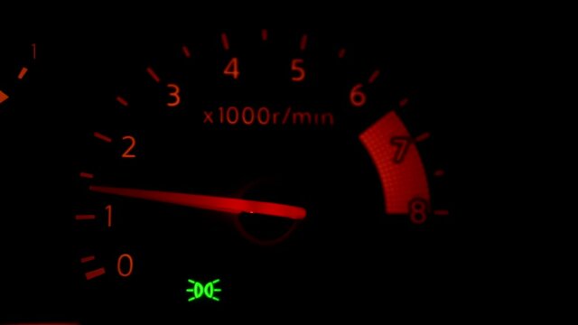 Close-up of a car tachometer in action.