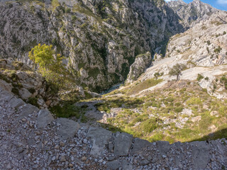 The Cares Route in the heart of Picos de Europa National Park, Cain-Poncebos, Asturias, Spain. Narrow and impressive canyon between cliffs, bridges, caves, footpaths and rocky mountains.