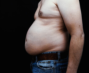 White male showing of an overweight belly from the side. Isolated on black background.