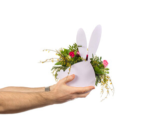 a man holds out a bouquet of flowers, decorated in a plywood vase in the shape of a hare. holidays, birthdays and weddings. isolated on white.