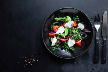 Greek salad tomato, cucumber, olives lettuce mix greens vitamins vegetable portion on the table healthy meal snack top view copy space for text food background rustic image keto or paleo diet