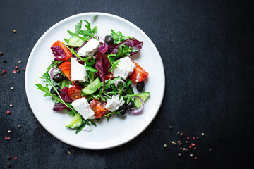 Greek salad tomato, cucumber, olives lettuce mix greens vitamins vegetable portion on the table healthy meal snack top view copy space for text food background rustic image keto or paleo diet