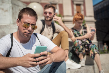 Alienation addiction. Group of friends using smartphones together. Young people addiction to new technology trends. Youth, new generation internet friendship concept. Emotional isolation and depresion