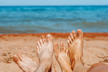 couple feet on the beach by the sea