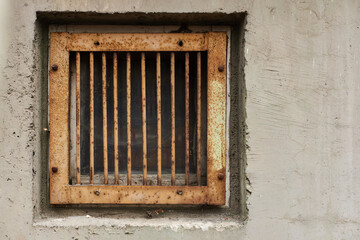 Fototapeta na wymiar Iron-barred window in suburb of Eastern Europe garage fear of theft first floor of old apartment building rust and aged wall texture with copy space for text on the right