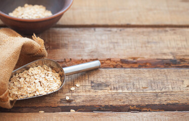 Oatmeal or oat flakes on wooden table.