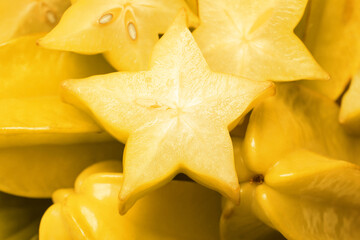 Cut and whole carambolas as background, closeup