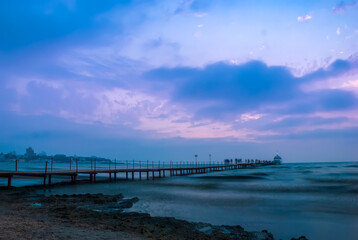 Fototapeta premium Seascape. Pier against the backdrop of sunset sky with beautiful clouds and sea waves. Anapa. Krasnodar Territory.
