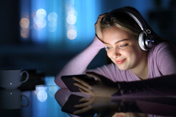 Happy teenage with headphones watching media on phone