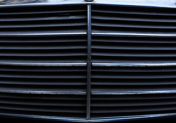 Closeup of car grill shiny chrome surface of vintage retro vehicle car part concept with lots of copy space for text