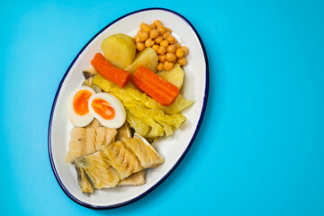 boiled cod fish with boiled vegetables and egg on white dish