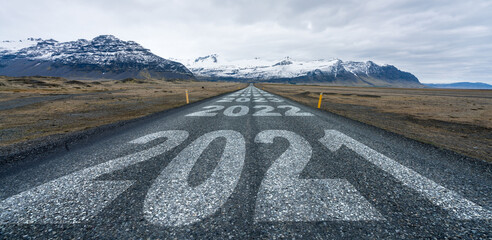 2021,2022,2023,2024 and so forth written on asphalt road leading towards infinity and mountain...