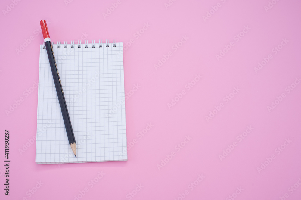 Poster overhead shot of a pencil on a grid notepad isolated on pink background with space for your text